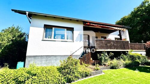 Titel Frontansicht Ki optimiert - Altengerechtes kompaktes Wohnhaus mit Terrasse Garage und großem Garten für Naturliebhaber