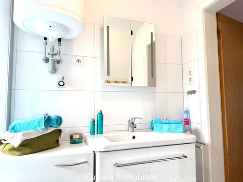 Modernes Badezimmer mit Spiegelschrank und großflächiger Keramikfliesen-Wandgestaltung - 