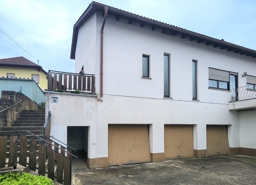 Hausansicht mit Garage (links) - Wohnen mit Wohlfühlfaktor – gepflegtes Haus mit Terrasse & Pelletheizung in Steinbach am Glan
