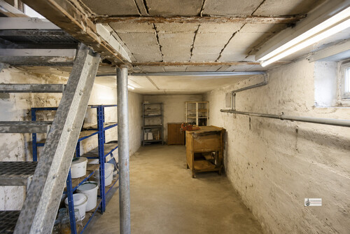Kellerraum mit Metalltreppe und Werkbank - 