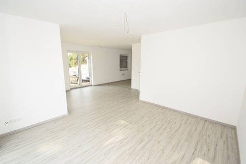 Das Wohnzimmer ist durch die großen Fensterelemente schön hell - 