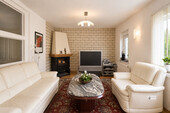 Wohnzimmer mit Kamin und Blick in den Garten - 