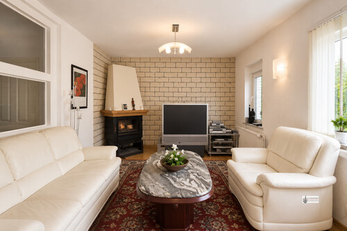 Wohnzimmer mit Kamin und Blick in den Garten - 