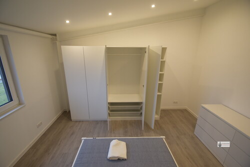 Schlafzimmer mit Bett, Schrank und Kommode - 