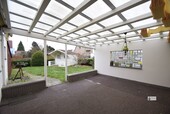 k-überdachte Terrasse mit Blick auf das Gartenhaus - 