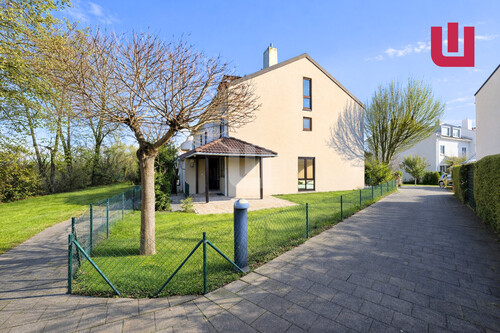 Außenansicht im Frühling (KI generiert) - WINDISCH IMMOBILIEN - Neu saniertes Reiheneckhaus in familienfreundlicher Lage