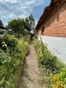 Seitlicher Gartenweg entlang der Backsteinfassade - 