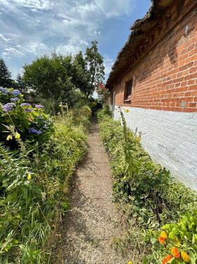 Seitlicher Gartenweg entlang der Backsteinfassade - 