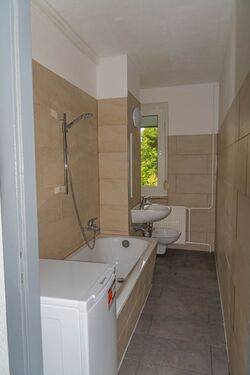 Badezimmer mit WC, Wanne, Waschmaschine und Fenster - 