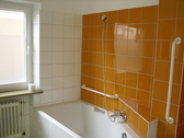 Sonniges Badezimmer mit Badewanne und Dusche - 