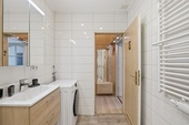 Badezimmer mit breitem Waschtisch, Waschmaschine und Handtuchheizung - 