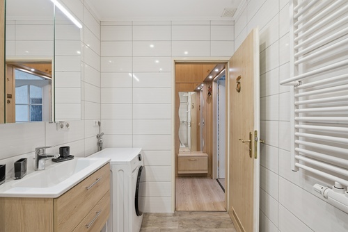 Badezimmer mit breitem Waschtisch, Waschmaschine und Handtuchheizung - 