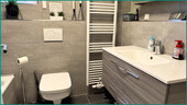 Modernisiertes Badezimmer mit Fenster und Handtuchheizkörper und... - 