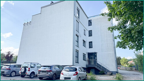 Ansicht der Gebäudeseite mit Hauszugang und Parkplätzen - 