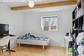 Helles Jugendzimmer mit Dachbalken und integriertem Stauraum - 