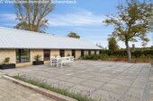 Weitläufige Terrasse mit hochwertiger Natursteinbelägen und freier Landschaftsaussicht - 