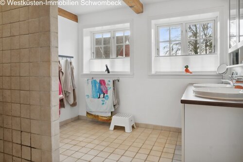 Helles Badezimmer mit großflächigen Fenstern und praktischer Doppelwaschanlage - 