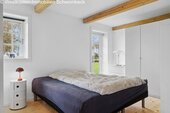 Helles Schlafzimmer mit Terrassenzugang und charaktervollen Holzbalken - 