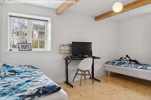 Helles Jugendzimmer mit Dachbalken, Arbeitsbereich und praktischer Raumaufteilung - 