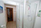 Modernes Badezimmer mit ebenerdiger Dusche und Glasabtrennung - 