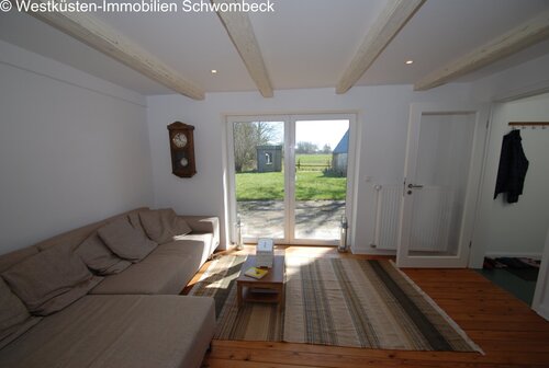 Lichtdurchflutetes Wohnzimmer mit Terrassenzugang und Deckenbalken - 