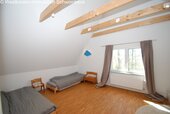 Dachgeschoss-Kinderzimmer mit Holzbalkendecke und großflächigen Fenstern - 