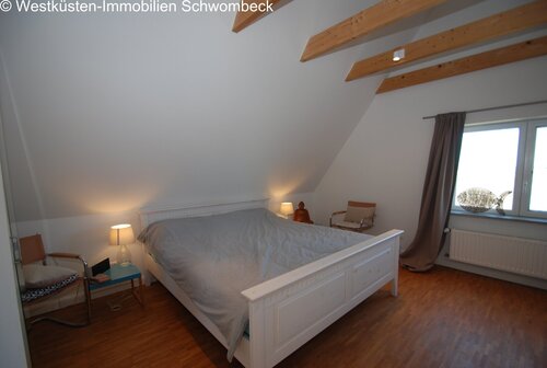 Gemütliches Dachschlafzimmer mit Holzbalkendecke und Dachfenstern - 