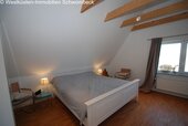 Dachgeschoss-Schlafzimmer mit Spitzbogenfenstern und Holzbalkendecke - 