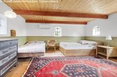 Dachgeschoss-Schlafbereich mit Holzbalkendecke und vielseitiger Raumaufteilung - 