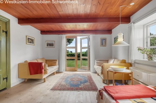Lichter Wohnbereich mit markanten Holzbalken und direktem Terrassenzugang zum Garten - 