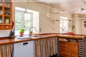 Küche mit Tresen und großflächigen Fenstern zum Garten - 