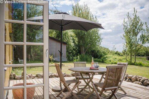 Sonnige Holzterrasse mit direktem Gartenblick und Freisitzbereich - 