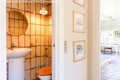 Elegantes Gäste-WC mit charaktervollem Fliesenspiegel und praktischer Ausstattung - 
