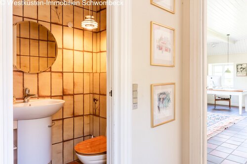 Elegantes Gäste-WC mit charaktervollem Fliesenspiegel und praktischer Ausstattung - 