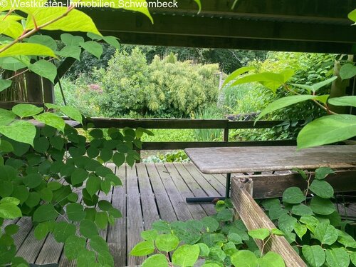 Überdachte Terrasse mit Blick auf den Gartenteich - 