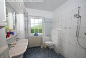 Modernes Badezimmer mit bodengleicher Dusche und Fensterbelichtung - 