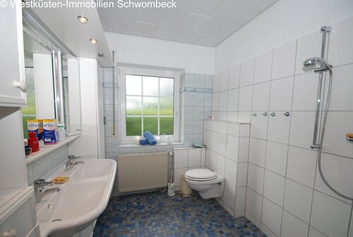 Modernes Badezimmer mit bodengleicher Dusche und Fensterbelichtung - 