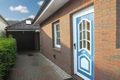 Gepflasterter Zugangsbereich mit direkter Gartenanbindung und überdachtem Eingang - 